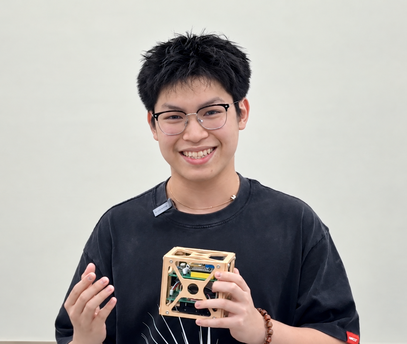 Huy Bui holding his CubeSat prototype